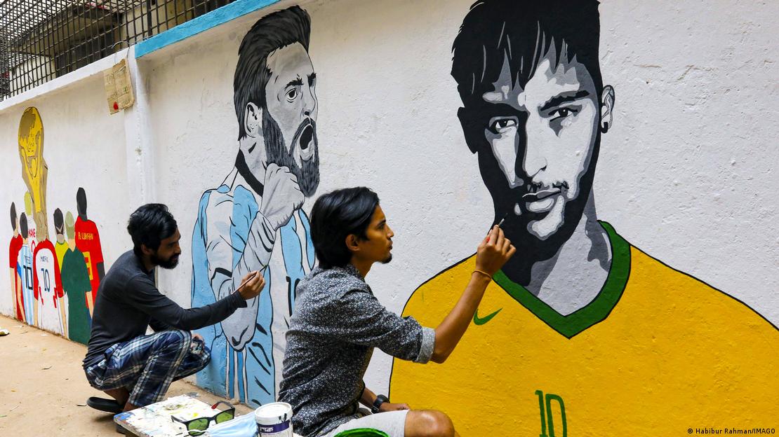 Homens pintam muro com imagens de Messi e Neymar