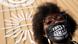 A Black woman wearing a mask saying "loss and damage finance now" A Black woman wearing a mask saying "loss and damage finance now"