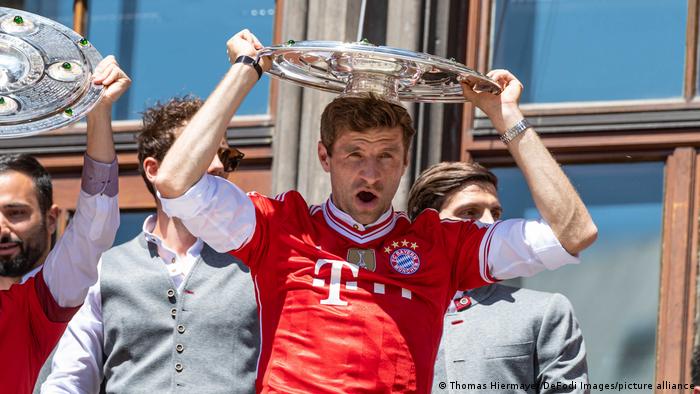 Thomas Müller von Bayern München setzt sich bei der Meisterfeier auf dem Münchener Rathausbalkon die Meisterschale auf den Kopf 
