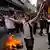 Demonstranten mit brennendem Reifen in enger Straße (Foto: AP)