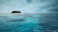 FUNAFUTI, TUVALU - NOVEMBER 26: An islet is viewed in the Funafuti atoll on November 26, 2019 in Funafuti, Tuvalu. The low-lying South Pacific island nation of about 11,000 people has been classified as ‘extremely vulnerable’ to climate change by the United Nations Development Programme. The world’s fourth-smallest country is struggling to cope with climate change related impacts including five millimeter per year sea level rise (above the global average), tidal and wave driven flooding, storm surges, rising temperatures, saltwater intrusion and coastal erosion on its nine coral atolls and islands, the highest of which rises about 15 feet above sea level. In addition, the severity of cyclones and droughts in the Pacific Island region are forecast to increase due to global warming. Some scientists have predicted that Tuvalu could become inundated and uninhabitable in 50 to 100 years or less if sea level rise continues. The country is working toward a goal of 100 percent renewable power generation by 2025 in an effort to curb pollution and set an example for larger nations. Tuvalu is also exploring a plan to build an artificial island. (Photo by Mario Tama/Getty Images)