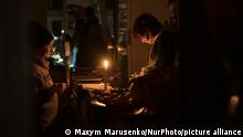 People in a shop that works in light candles during a blackout after a massive Russian missile attack on Ukrainian power infrastructure in Lviv, Ukraine, November 15, 2022 (Photo by Maxym Marusenko/NurPhoto)