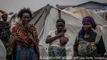Women discuss the state of the Nyiragongo volcano disaster at the Kayembe camp for dislaced people, near Goma on August 30, 2021. - 4,000 or so households living in a camp for displaced people set up in a schoolyard in Kayembe, 4 km north of Goma.
More than three months after the eruption of the Nyiragongo volcano in eastern Democratic Republic of Congo, thousands of people are still living in makeshift shelters around Goma and calling for help. (Photo by Guerchom NDEBO / AFP) (Photo by GUERCHOM NDEBO/AFP via Getty Images)