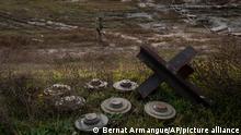Ein ukrainischer Soldat sucht auf dem Feld eines kürzlich befreiten Dorfes am Rande von Cherson nach Minen. +++ dpa-Bildfunk +++