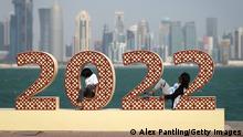 DOHA, QATAR - NOVEMBER 20: Supporters sit on 2022 signage ahead of the FIFA World Cup Qatar 2022 at on November 20, 2022 in Doha, Qatar. (Photo by Alex Pantling/Getty Images)