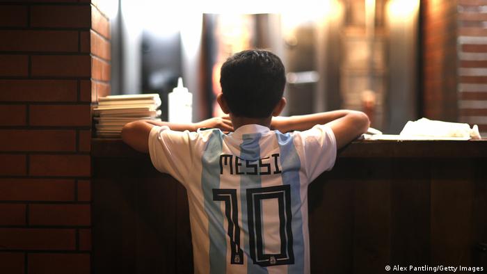 Un joven hincha argentino de Messi observa un desfile en Doha
