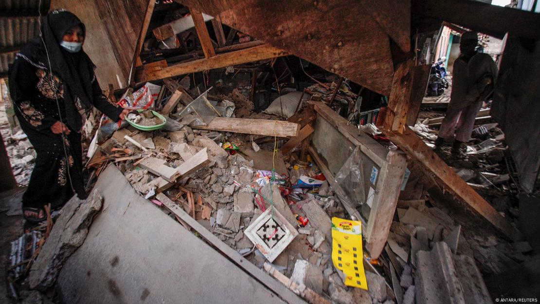  A local collects her goods from the house damaged after earthquake hit in Cianjur, West Java province, Indonesia