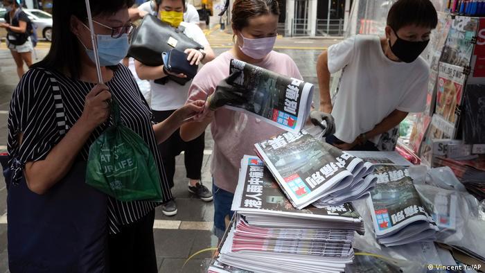2021年人们在香港一家报摊前排队购买最后一期、现已停刊的《苹果日报》。