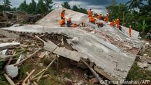 TOPSHOT - Rescue workers look for victims under the ruins of collapsed buildings in Cianjur on November 22, 2022, following a 5.6-magnitude earthquake that killed at least 162 people, with hundreds injured and others missing. (Photo by TIMUR MATAHARI / AFP)