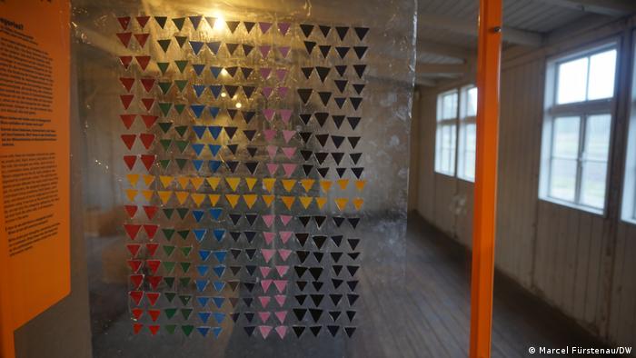 266 Dreiecke in den Farben Rot, Grün, Schwarz, Gelb, Rosa und Blau sind auf einer transparenten Kunststofffolie befestigt. Der Künstler hat seiner Installation in der KZ-Gedenkstätte Sachsenhausen den Namen Categories gegeben. 