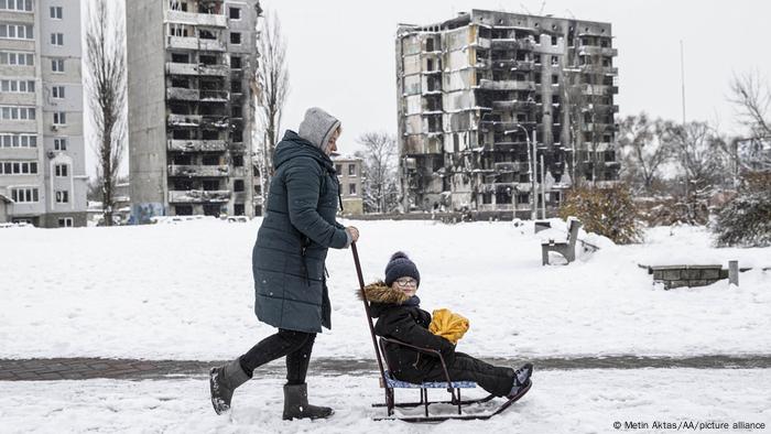Madre pasea con su hijo por las calles nevadas de Borodianka