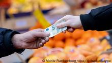 Ein Kunde bezahlt seinen Einkauf an einem Stand auf einem Wochenmarkt mit einem Fünf-Euro-Schein (gestellte Szene). Nach dem Preisschub im Jahr 2021 hoffen Verbraucher in Deutschland auf Entspannung bei der Teuerung. Wie sich die Inflation im Januar 2022 entwickelt hat, gibt das Statistische Bundesamt am Nachmittag (31.01.2022) in einer ersten Schätzung bekannt. Im Dezember 2021 waren die Verbraucherpreise gegenüber dem Vorjahresmonat um 5,3 Prozent gestiegen.