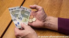 Bamberg, Deutschland 19. Januar 2022: Zeitgeschehen - Themenbild - Altersarmut Eine ältere Person hält in ihren Händen 10,45 Euro Bargeld in Euromünzen und Euroscheinen.