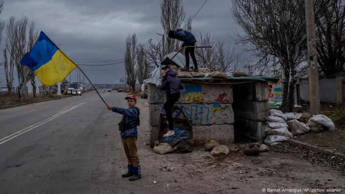 Niños ucranianos juegan en un puesto de control abandonado en Jersón, sur de Ucrania (23.11.2022)