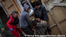 Neighbours and paramedics evacuate Viktor Anastasiev to a hospital after he was injured during a Russian strike in Kherson, southern Ukraine, Thursday, Nov. 24, 2022. (AP Photo/Bernat Armangue)