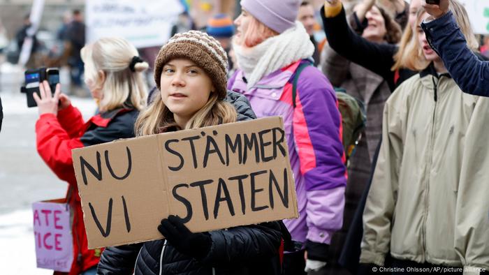 Greta Thunberg, con una pancarta en la calle.