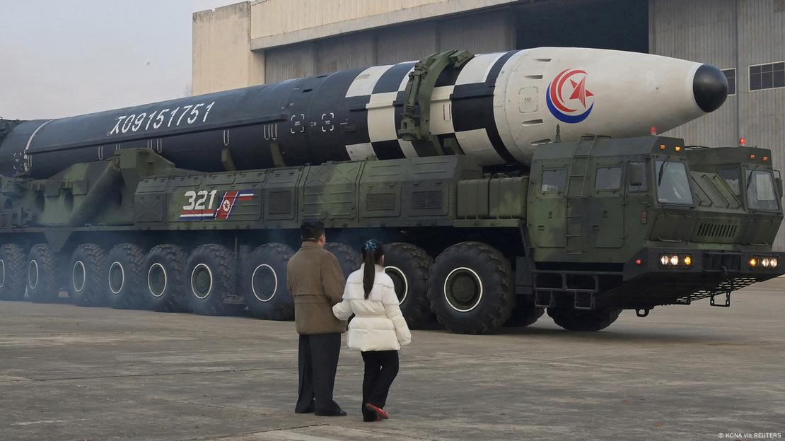 Kim Jong Un and his daughter pose for a propaganda photo in front of an ICBM