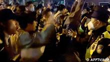 This frame grab from eyewitness video footage made available via AFPTV on November 27, 2022 shows demonstrators shouting slogans as police hold their positions, in Shanghai. - Angry crowds took to the streets in Shanghai in the early hours of November 27 and videos on social media showed protests in other cities across China, as public opposition to the government's hardline zero-Covid policy mounts. (Photo by AFPTV / AFP)