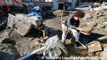 People remove mud and debris after heavy rainfall triggered landslides that collapsed buildings and left as many as 12 people missing, in Casamicciola, on the southern Italian island of Ischia, Sunday, Nov. 27, 2022. Authorities said that the landslide that early Saturday destroyed buildings and swept parked cars into the sea left one person dead and 12 missing. (AP Photo/Salvatore Laporta)
