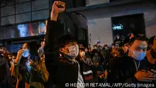 People sing slogans while gathering on a street in Shanghai on November 27, 2022, where protests against China's zero-Covid policy took place the night before following a deadly fire in Urumqi, the capital of the Xinjiang region. (Photo by Hector RETAMAL / AFP) (Photo by HECTOR RETAMAL/AFP via Getty Images)