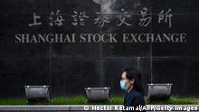 Archiv 04.11.2020+++ A pedestrian walks past the Shanghai Stock Exchange in Shanghai on November 4, 2020. (Photo by Hector RETAMAL / AFP) (Photo by HECTOR RETAMAL/AFP via Getty Images)
