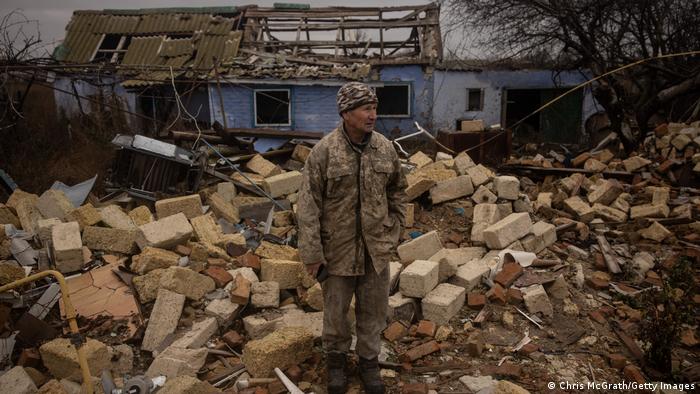 In Cherson steht ein Mann vor den Trümmern eines Hauses, in dem sieben Menschen einem russischen Angriff zum Opfer fielen