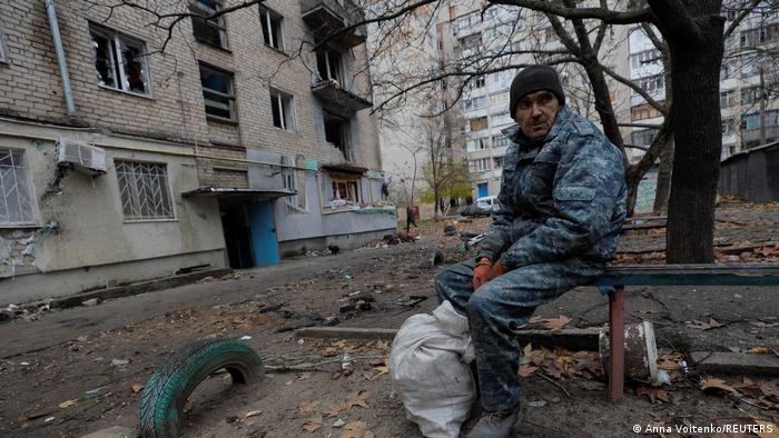 Në Kherson, një burrë qëndron para rrënojave të dëmtuar nga rusët.