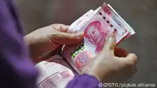 FUYANG, CHINA - NOVEMBER 25, 2022 - Residents count Chinese yuan in Fuyang, Anhui province, China, Nov 25, 2022. The central bank said in a statement that it decided to cut the reserve requirement ratio (RRR) for financial institutions by 0.25 percentage points on December 5, 2022 (excluding financial institutions that have already implemented the RRR of 5%). After this cut, the weighted average deposit reserve ratio of financial institutions is about 7.8 percent.