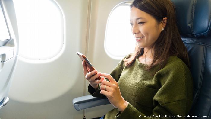 Mujer con un teléfono inteligente en un avión.