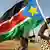 Ein Mann mit einer Fahne des Südsudan (Foto: dpa)