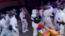 Riot police in personal protection suits (PPE) walk down a street, during protests over coronavirus disease (COVID-19) restrictions, in Guangzhou, Guangdong province, China in this screen grab taken from a social media video released November 29, 2022. Video Obtained by Reuters/via REUTERS THIS IMAGE HAS BEEN SUPPLIED BY A THIRD PARTY. MANDATORY CREDIT. NO RESALES. NO ARCHIVES. THIS PICTURE WAS PROCESSED BY REUTERS TO ENHANCE QUALITY. AN UNPROCESSED VERSION HAS BEEN PROVIDED SEPARATELY.