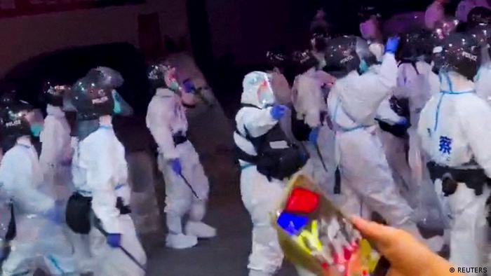 Полицаи, облечени в предпазни костюми, по време на протестите в Гуанджоу.