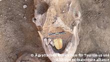 Eine Mumie mit einem zungenartigen Amulett im Mund (undatierte Aufnahme). Archäologen haben an der ägyptischen Mittelmeerküste zwei solcher Mumien entdeckt. Ein spezieller Ritus mit den goldenen Zungen sollte ihnen wohl ermöglichen, im Jenseits mit dem dort herrschenden Gott Osiris zu sprechen, teilte das ägyptische Antikenministerium mit. (zu dpa Goldene Zunge: Mumien mit Amuletten im Mund entdeckt) +++ dpa-Bildfunk +++