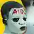 Weiß-geschminktes Gesicht mit den Buchstaben "AIDS" in Rot auf der Stirn 