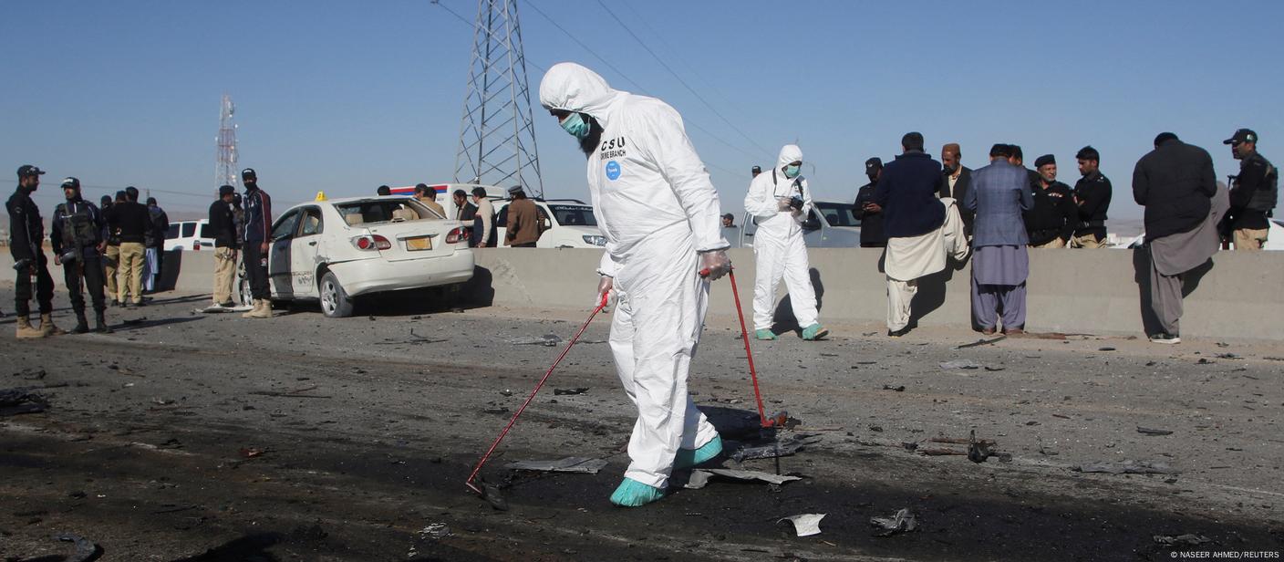 A member of a crime scene unit surveys the site after a suicide bomb blast on a police patrol in Quetta on November 30, 2022