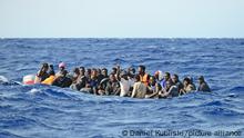 Migration über das zentrale Mittelmeer. Ein Holzboot mit etwa 30 Menschen versucht bei hohen Wellengang die gefährliche Überfahrt nach Italien. Oft geraten diese labilen und überfüllten Boote in Seenot.