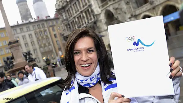 Katarina Witt hält das sogenannte Bid Book hoch, mit dem sich München für die Olympischen Winterspiele 2018 bewirbt. Foto: dapd