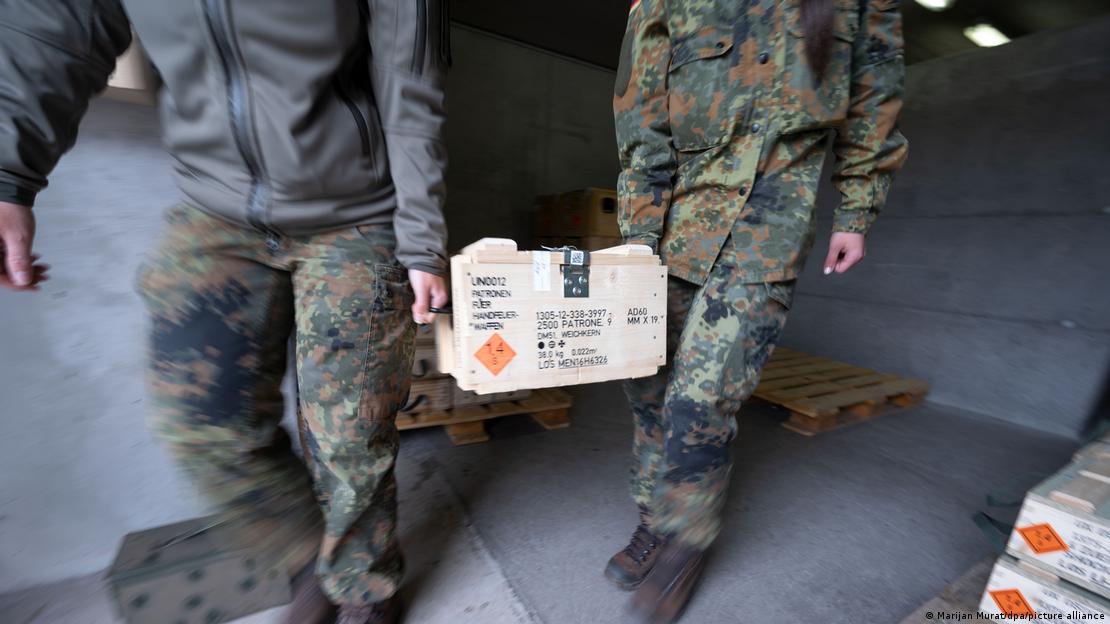 Dos soldados mueven una caja de munición.