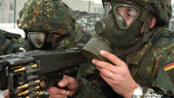 Zwei Bundeswehr-Soldaten mit Gasmasken und Waffen im Anschlag