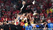 Morocco's coach #00 Walid Regragui is thrown into the air after winning the Qatar 2022 World Cup Group F football match between Canada and Morocco at the Al-Thumama Stadium in Doha on December 1, 2022. (Photo by Patrick T. Fallon / AFP)