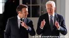 President Joe Biden and French President Emmanuel Macron talk as they walk along the Colonnade of the White House in Washington, Thursday, Dec. 1, 2022. (Jim Watson/Pool Photo via AP)