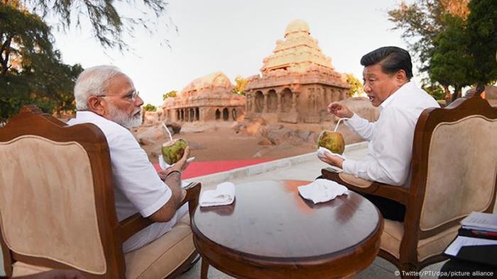 Xi Jinping, Präsident von China, und Narendra Modi, Premierminister von Indien, trinken während eines Gesprächs aus Kokosnüssen.