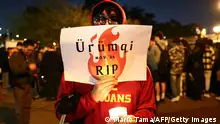 LOS ANGELES, CALIFORNIA - NOVEMBER 29: A demonstrator holds a sign reading Urumqi RIP sign at a candlelight vigil at University of Southern California (USC) honoring those who perished in an apartment building fire in Urumqi, China, amid a months-long Covid lockdown on November 29, 2022 in Los Angeles, California. The government has reported that at least 10 people died in the fire, sparking public anger and protests against Covid lockdowns in several cities in China. The vigil also honored those who have suffered and died of hunger during China Covid Zero. Mario Tama/Getty Images/AFP (Photo by MARIO TAMA / GETTY IMAGES NORTH AMERICA / Getty Images via AFP)