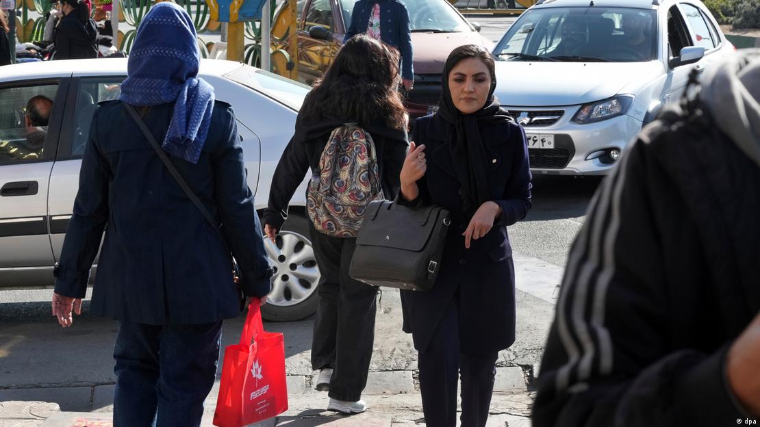A women crosses a street in Tehran without a headscarf 