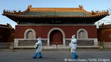 BEIJING, CHINA - DECEMBER 03: Epidemic control workers wear PPE as they walk by the Huangsi Temple on their way to perform nucleic acid tests on people under lockdown or health monitoring for COVID-19 on December 3, 2022 in Beijing, China. (Photo by Kevin Frayer/Getty Images)
