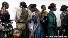 Models wait to get their make-up finished during Dakar fashion week on Goree Island in Dakar, Senegal, on December 03, 2022. - The 20th anniversary of Dakar fashion week is held in a preserved colonial era fort on Goree island, which was one of Africa’s biggest slave trading centres during the 15th and 16th century. (Photo by JOHN WESSELS / AFP)