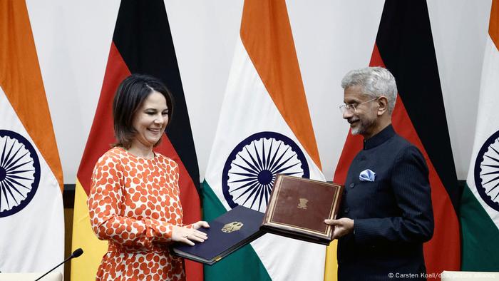 La ministra alemana de Relaciones Exteriores, Annalena Baerbock, intercambia carpetas en firma de acuerdos, con su homólogo indio Subrahmanyam Jaishankar.