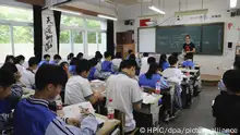 Students attend class in a classroom equipped with a surveillance camera at a high school in Hangzhou city, east China's Zhejiang province, 15 May 2018. The classrooms of a high school in Hangzhou city, Zhejiang province, have been equipped with surveillance cameras to monitor the students in class. The system can not only record the attendance of students, but also tell whether they are absentminded in class. The face recognition technology has been applied to many areas of the school life. Students just have their face scanned by devices to buy their lunch meals and borrow books from school library.