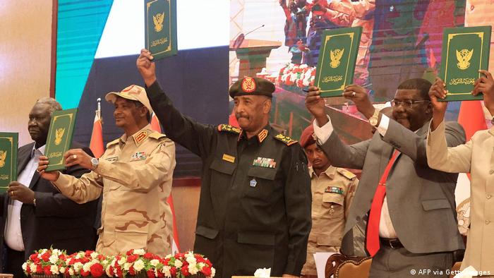 Armeechef Abdel Fattah al-Burhan (Mitte) und RSF-Anführer Mohammed Hamdan Daglo (Zweiter von links) heben ein gerade unterzeichnetes Abkommen in die Höhe