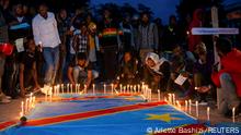 Congolese activists light candles on their national flag during a vigil in memory of the civilians killed in the recent conflict between Armed Forces of the Democratic Republic of the Congo (FARDC) and rebel forces, in Goma, in the North Kivu province of the Democratic Republic of Congo December 5, 2022. REUTERS/Arlette Bashizi